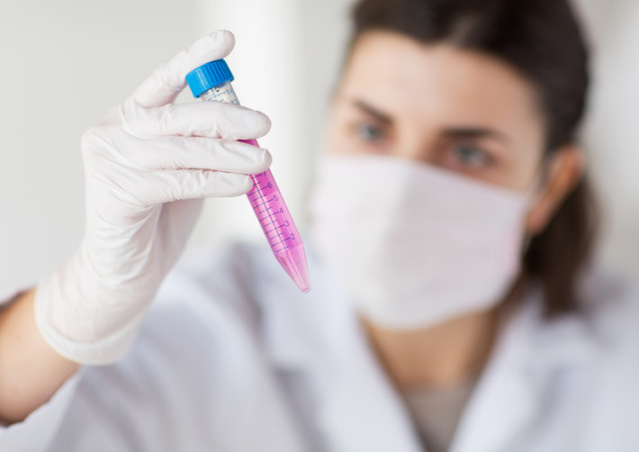 close up of scientist with tube making test in lab